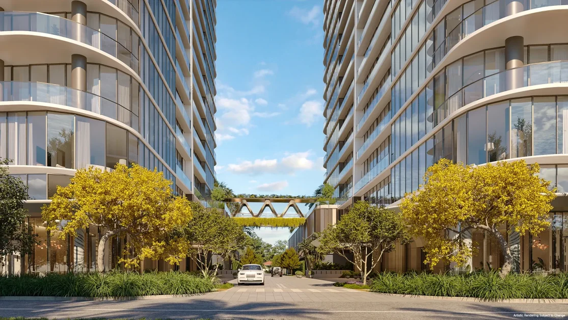 Private landscaped drive between twin residential towers connected by a signature amenity bridge