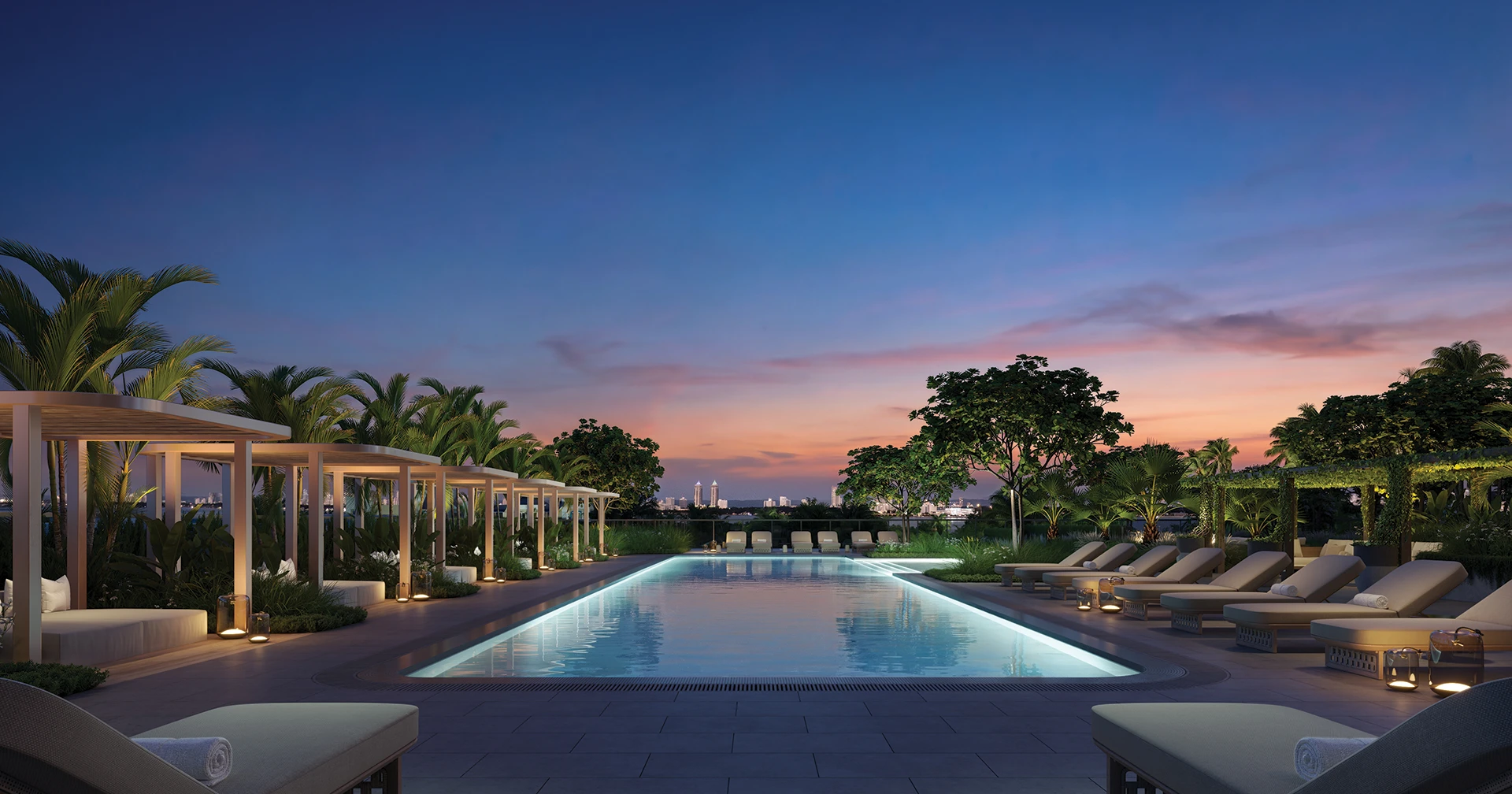 North pool at Kempinski Residences Miami Design District illuminated at evening with cabanas, lounge seating, and tropical landscaping