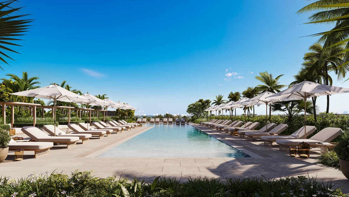 South pool area at Kempinski Residences Miami Design District with lounge chairs, umbrellas, tropical landscaping, and palm trees