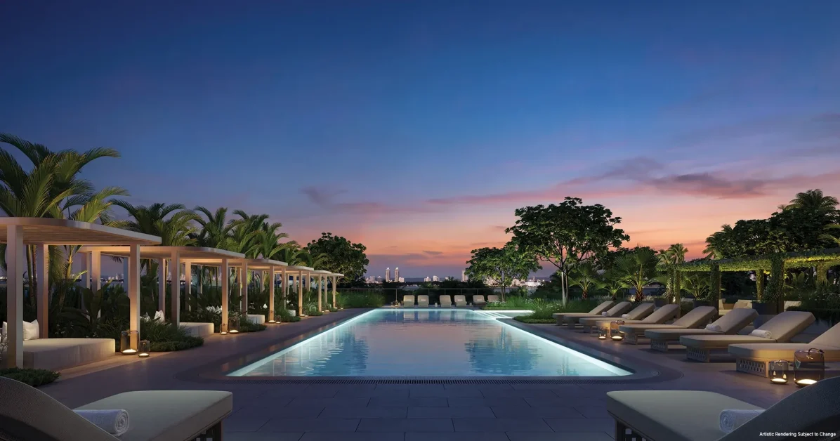 North pool at Kempinski Residences Miami Design District illuminated at evening with cabanas, lounge seating, and tropical landscaping
