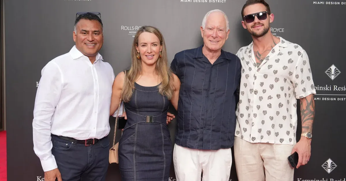 Four guests pose together at the Kempinski Residences Miami Design District launch event, smiling in front of the branded step-and-repeat backdrop.