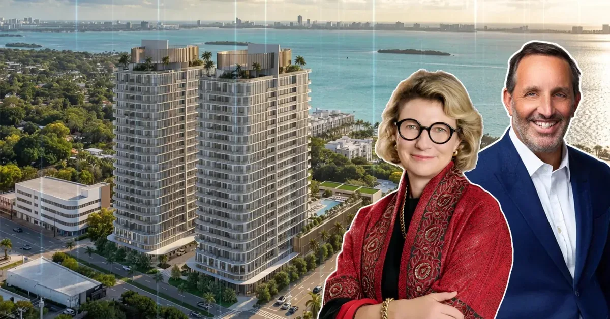 Two real estate professionals pose before a luxury Miami waterfront high-rise development with Biscayne Bay views in the background.