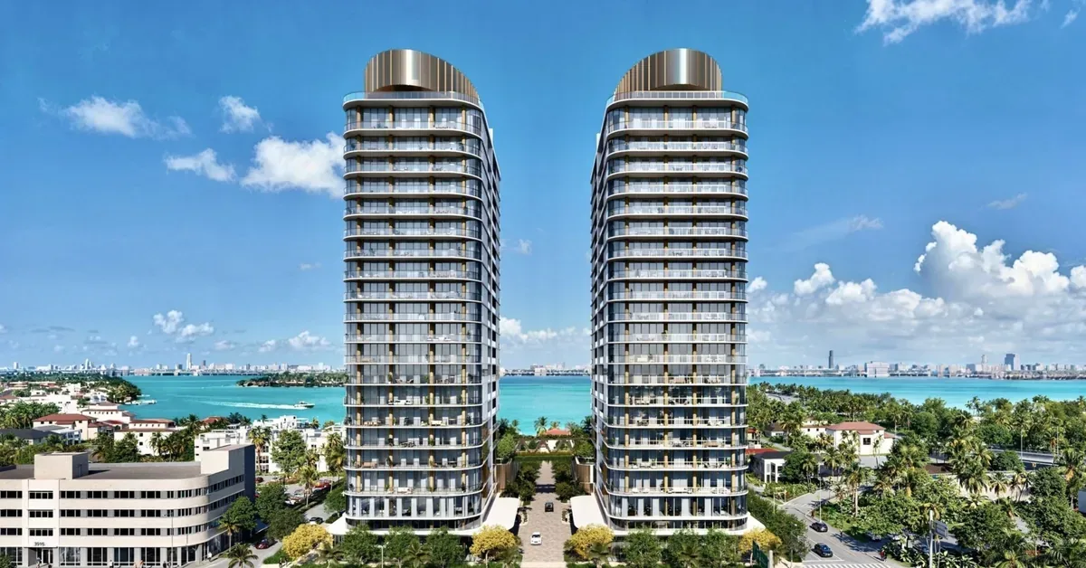 Twin luxury residential towers rise above Miami's waterfront neighborhood, showcasing modern curved architecture with wraparound balconies against turquoise ...