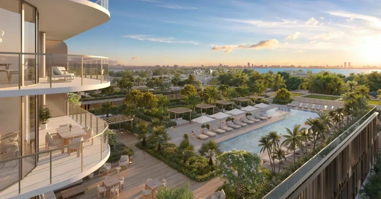 Luxury high-rise balconies overlook a resort-style pool deck with lounge chairs, lush tropical landscaping, and a sweeping Miami skyline at golden hour.