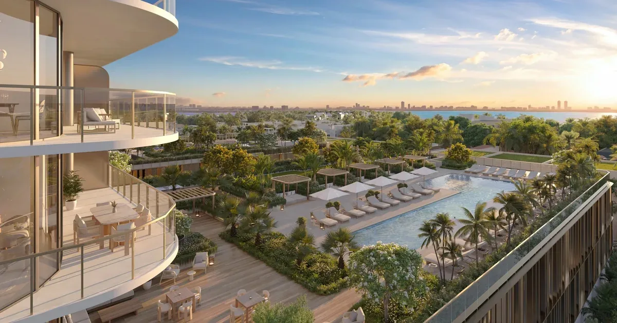 Luxury high-rise balconies overlook a resort-style pool deck with lounge chairs, lush tropical landscaping, and a sweeping Miami skyline at golden hour.