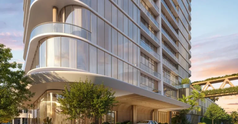 Luxury high-rise condominium tower featuring curved glass balconies, a grand porte-cochère entrance, and a white Rolls-Royce at dusk.