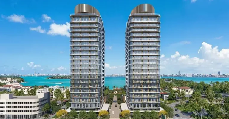 Twin luxury residential towers rise above Miami's waterfront neighborhood, offering panoramic views of turquoise Biscayne Bay and the downtown skyline beyond.