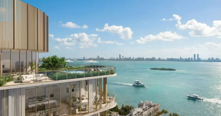 Luxury waterfront high-rise featuring gold-accented balconies, rooftop infinity pool, and sweeping turquoise bay views with a gleaming city skyline beyond.